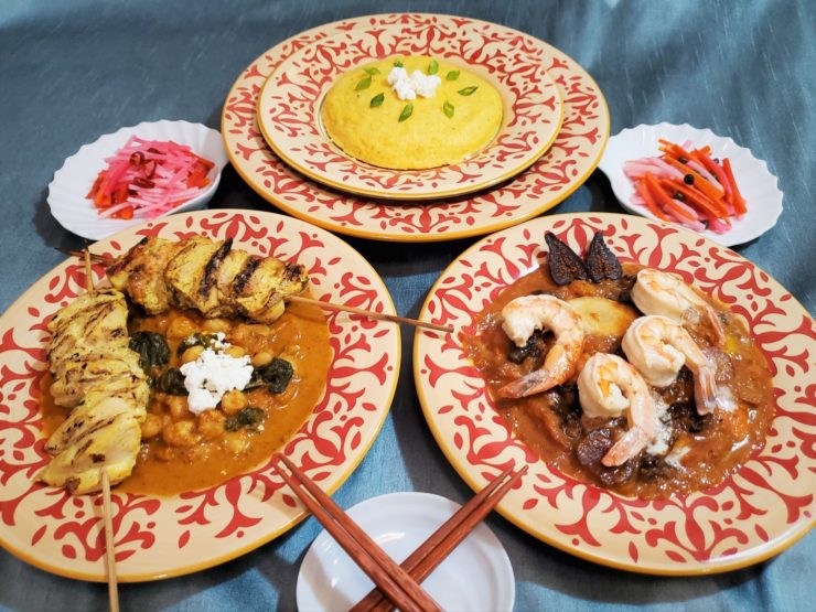 Photo of several plates of food, including polenta and two types of curry