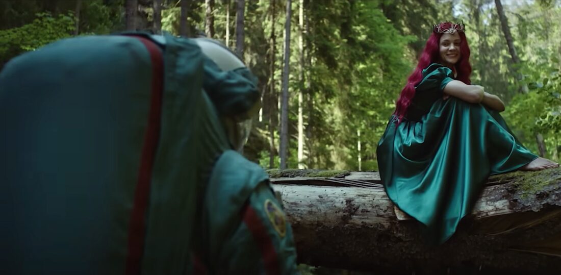 Carey Mulligan, dressed as folk character Rusalka and sitting on a fallen tree, in Spaceman